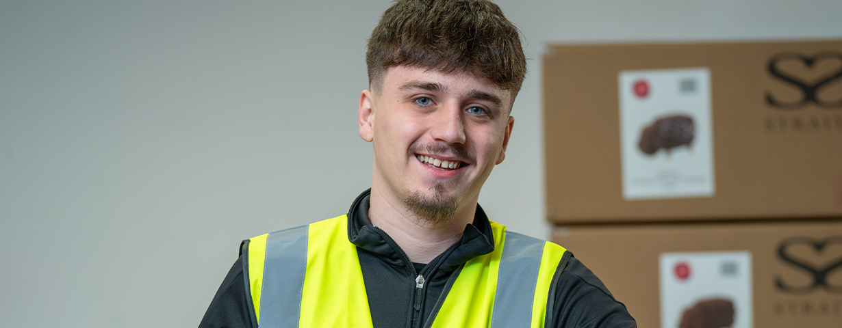 Young male learner wearing a high vis on placement at British Heart Foundation